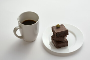 Coffee cup and green marijuana on cake pieces