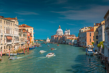 Busy boat traffic on the Grand Canal in Venice with the famous Santa Maria della Salute Basilica in the background