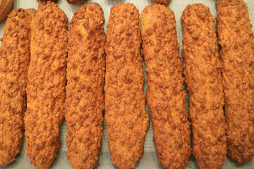 Row of Fresh Baked Piped Choux Pastry Crust with Craquelin During Cooling Dawn before Cream Filled
