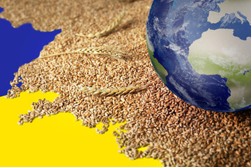 Global food crisis concept. Wheat grains and globe of Earth on table in colors of Ukrainian flag