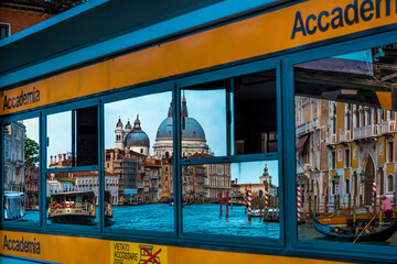 Reflection of the famous Basilica Santa Maria della Salute in a window of a local Vaporetto stop at...
