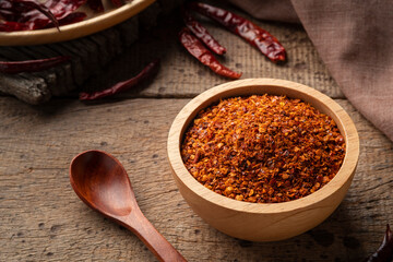 Dried red hot chilli powder in wooden bowl.Hot and spicy asian Condiments