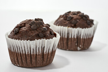 Two sweet chocolate cupcakes on white background