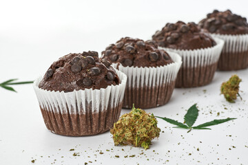 Cropped of cupcakes in row with green marijuana