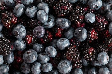 Background of blueberries and blackberries top view. Horizontal orientation, flatlay, no people