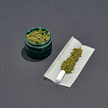 Marijuana in jar and on paper for rolled joint