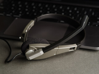 Modern headphones on a laptop on a gray background. Home office, workplace of a blogger, journalist, student, freelancer. Listening to video lessons, music. Advertising, banner.