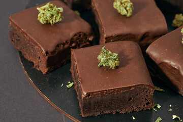 Cropped of sweet cake pieces and marijuana buds
