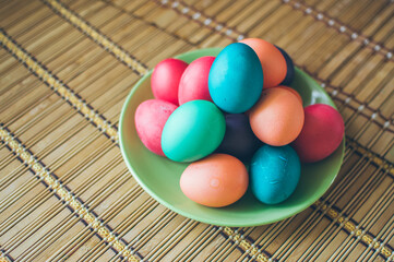 Fototapeta na wymiar Bright multicolored painted Easter eggs on green ceramic plate