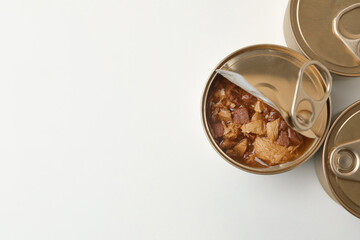 Tin cans with wet cat food on white background, top view. Space for text