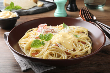 Delicious spaghetti with cheese sauce and meat on wooden table