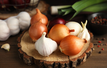 Fresh onion bulbs and garlic on wooden table