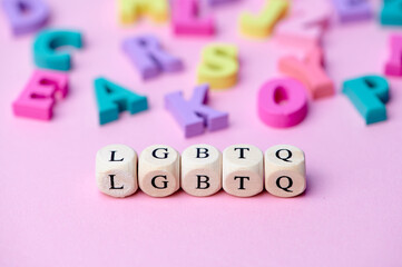 LGBTQ abbreviation: lesbian, gay, bisexual, transgendered, queer from wooden letters on pink...