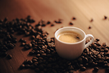 Taza de café, taza blanca, rodeado de granos de café, en mesa de madera, mesa de café, en la mañana