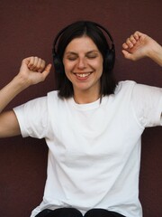 Young brunette woman wearing headphones. Young and stylish woman with dark short hair wearing a...