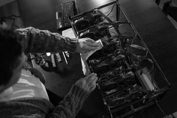 Man wiping cryptocurrency mining rig with rag