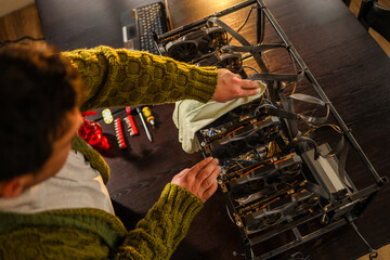Man wiping cryptocurrency mining rig with rag
