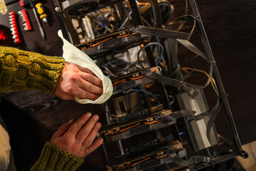 Man wiping cryptocurrency mining rig with rag