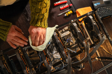 Man wiping cryptocurrency mining rig with rag