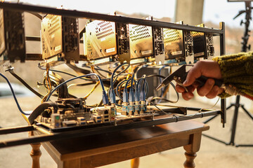Man cleaning dust from cryptocurrency mining rig with air compressor