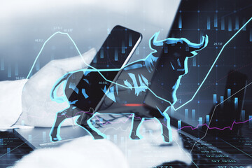 Concept of bullish market. Close up of businessman hands using laptop and smartphone with glowing bull hologram over forex chart on blurry background. Trade and invest concept. Double exposure.