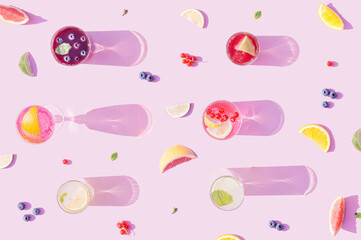 Colorful drink cocktail with fruits on a pastel pink background. Summer aesthetic fruity table with refreshing drinks.