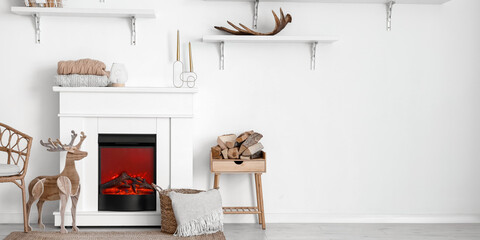 Electric fireplace in light room decorated for Christmas