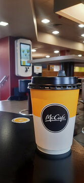 McCafe hot drink in a paper cup on a table in McDonalds fast food restaurant