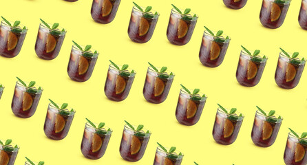 Glasses of tasty Cuba Libre cocktail on yellow background. Pattern for design