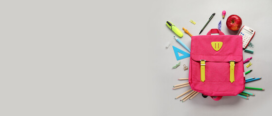 School backpack and stationery on grey background with space for text