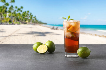 Glass of fresh Cuba Libre cocktail on table at tropical resort