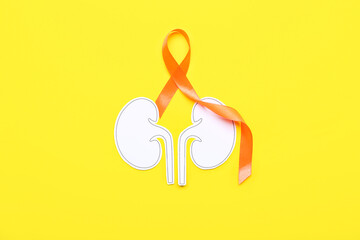 Orange awareness ribbon and paper kidneys on yellow background