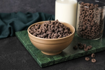 Bowl of black cereal rings on dark background