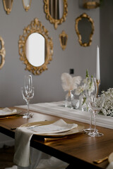 Aesthetic table setting in the restaurant for the holiday with flowers and gold, glasses
