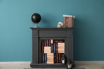 Black mantelpiece with books, human skull and globe near blue wall