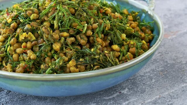 Dill leaves with moong bean. Shepu bhaji Indian cuisine dish, close-up. Table spin.