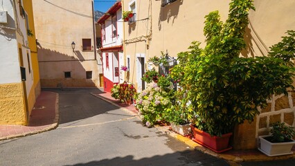 Fototapeta na wymiar Casco antiguo y coloridas casas en calles estrechas de la población de Polop de la Marina en Alicante junto a Benidorm.
