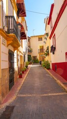 Fototapeta na wymiar Casco antiguo y coloridas casas en calles estrechas de la población de Polop de la Marina en Alicante junto a Benidorm.