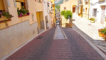 Obraz premium Casco antiguo y coloridas casas en calles estrechas de la población de Polop de la Marina en Alicante junto a Benidorm.