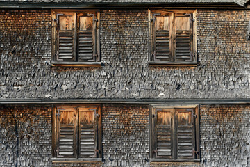 Alte Holzschindel Fassade mit vier geschlossenen Fensterladen, aus dem Bregenzer Wald