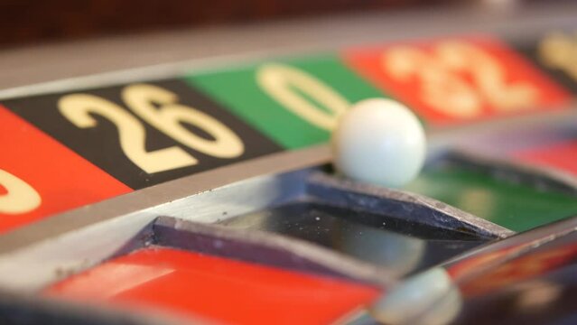 Ball on wooden french roulette table in casino. Wheel spinning, turning or rotating. Odd and even numbers, black, red and zero sectors. Bets in game of chance. Money playing, gambling or risky betting