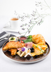 french breakfast of croissant, brioche bread, cheese and ham with butter on a plate
