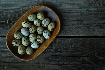 Fototapeta na wymiar Fresh quail eggs close up on a wooden table small hard boiled eggs rustic top view