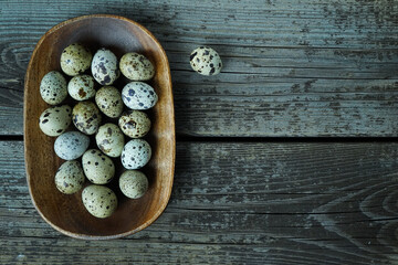 Obraz na płótnie Canvas Fresh quail eggs close up on a wooden table small hard boiled eggs rustic top view