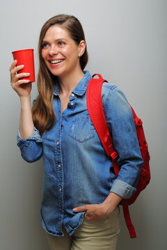 female student with red backpack and big coffee glass looking side awy. isolated female portrait.