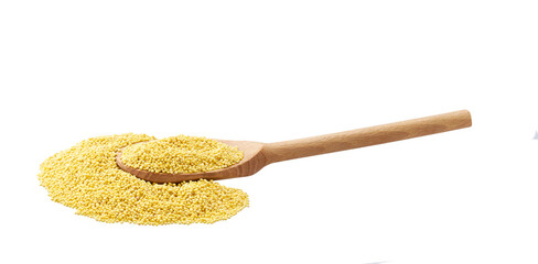 dry grains of millet crumble from a wooden spoon isolated on white background.