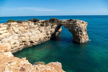 Fototapeta na wymiar Natural Arch of Albandeira during low tide. Landmark in Lagoa, Algarve.