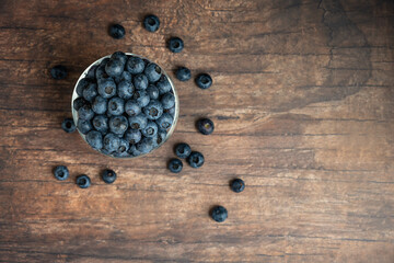 Obraz na płótnie Canvas Glass goblet of fresh, nutritious, tasty blueberries on a rustic wood background 