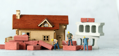 Miniature builders remodeling house. Miniature people and business concept.
