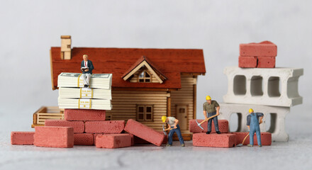 Business concept with miniature house and miniature people. The concept of income disparity.
